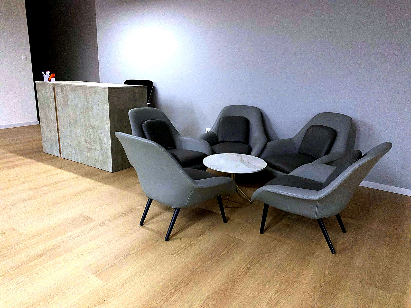 The Flexed lounge with grey leather armchairs around a marble table, where tenants are welcomed.